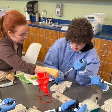 Stephanie demonstrating how to use a pipette at RiseHigh