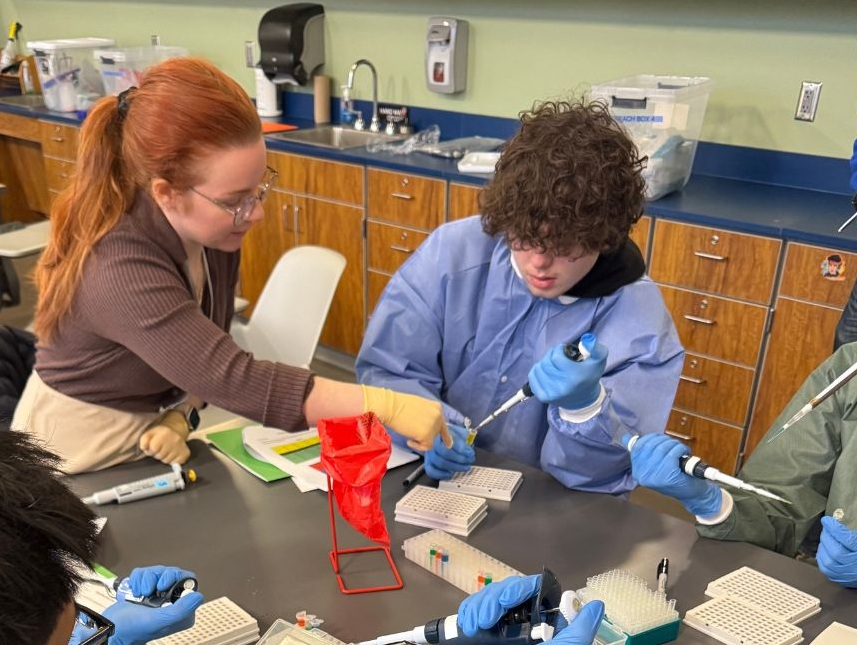 Stephanie demonstrating how to use a pipette at RiseHigh